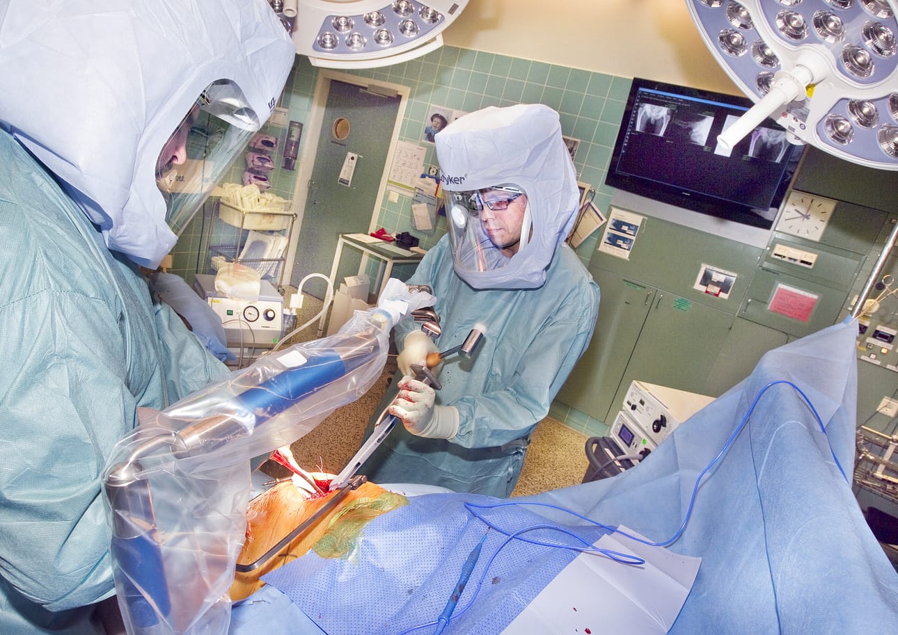 "Lonkkaproteesin haitoista kärsivät potilaat voivat nyt soittaa omaan palvelunumeroon", kertoo Oysin tekonivelkirurgiasta vastaava ortopedi Ari-Pekka Puhto (oikealla). Puhto tekee kuvassa lonkan tekonivelleikkausta potilaalle assistentti Anton Serovin kanssa.