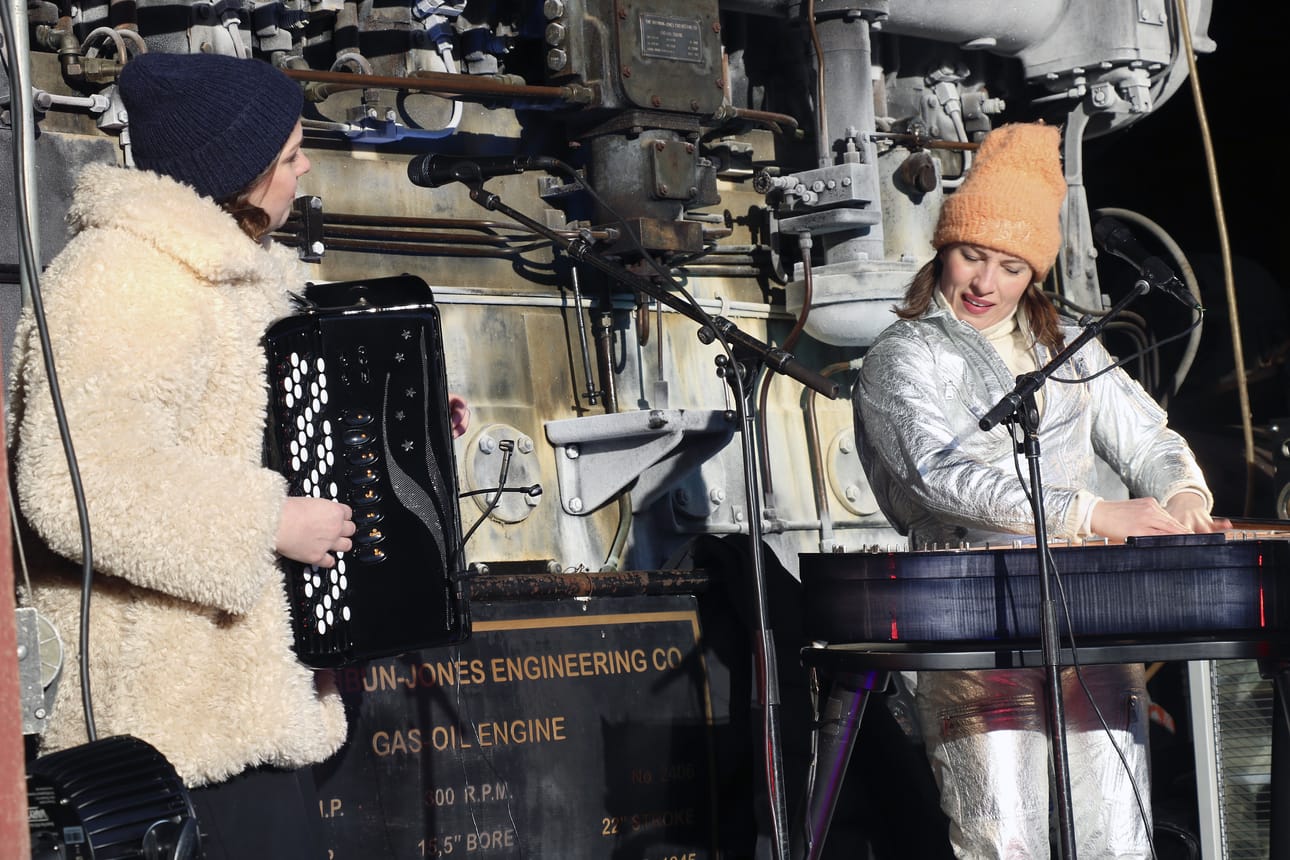 Haapavetislähtöinen haitarinsoittaja Teija Niku ja oulaistelaislähtöinen popkanteletar Ida Elina tarkenivat soittaa suurten moottoreiden kupeesa ulkona. Molemmat muusikot ovat lähiaikoina saavuttaneet taidoillaan mainetta ulkomaila.