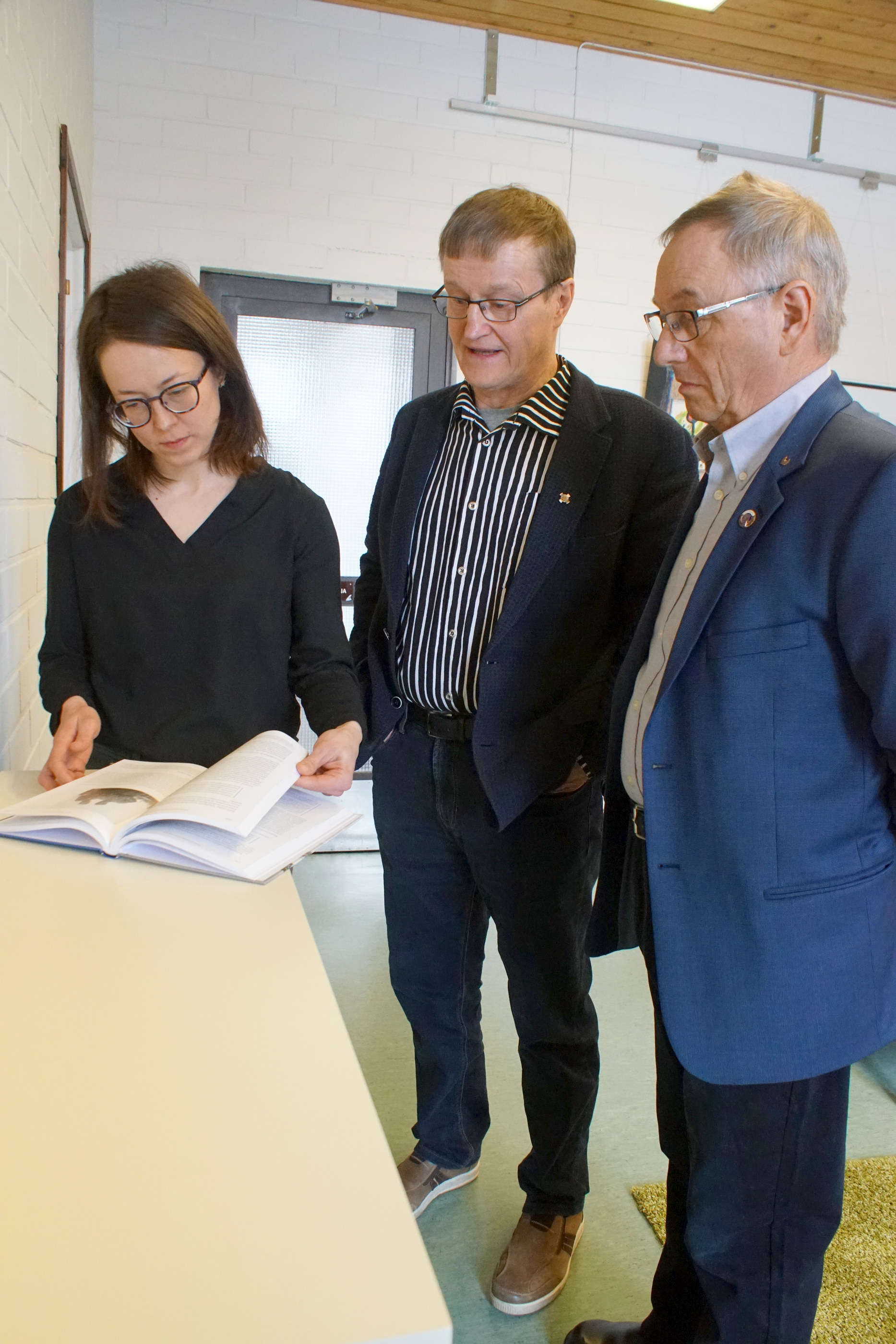 Paavo Ervasti (oik.) ja Vesa Holmström luovuttivat kirjan kirjastonjohtaja Outi Nivakoskelle ja lainaajien käyttöön.