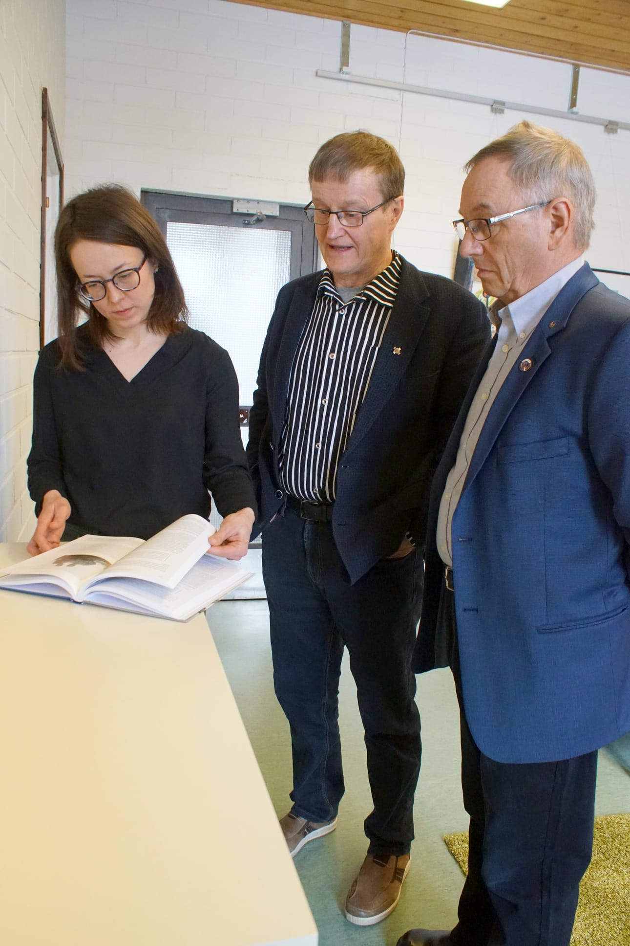 Paavo Ervasti (oik.) ja Vesa Holmström luovuttivat kirjan kirjastonjohtaja Outi Nivakoskelle ja lainaajien käyttöön.