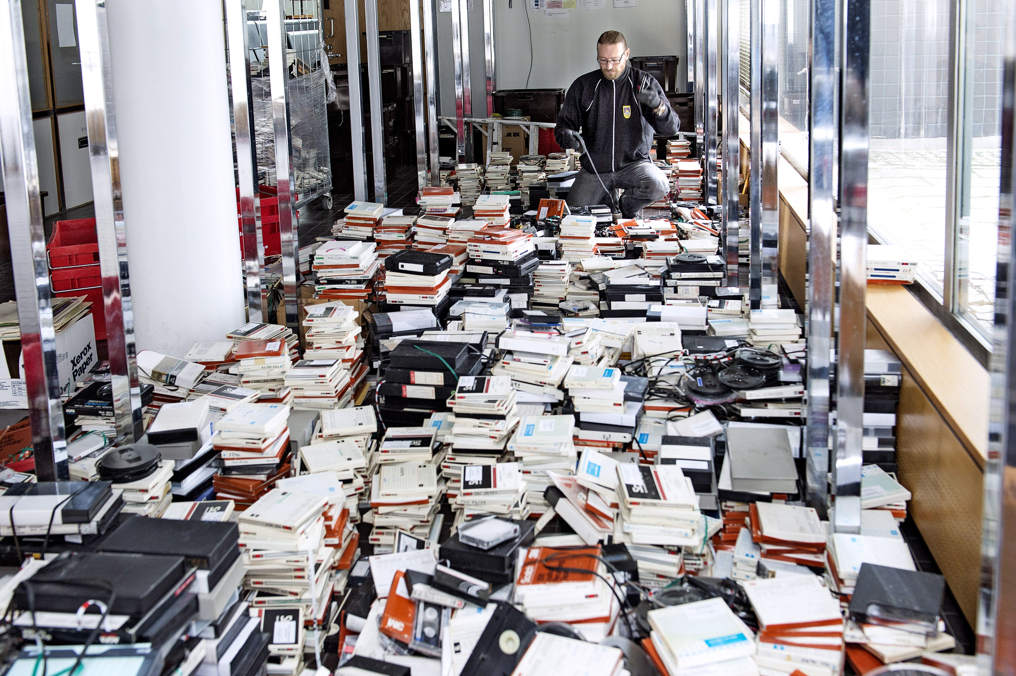 Arkistosihteeri Aki Luotonen tutki tiistaina roskalavalle räntäsateeseen joutuneen TKU-kokoelman tuhojen laajuutta.