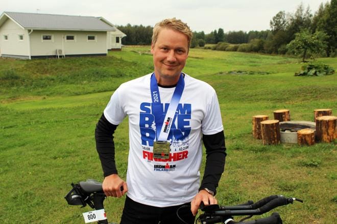 Hymy ei ole hyytynyt Viinikaisen kasvoilta vaikeista ajoista huolimatta. Kaulaa koristaa nyt mitali teräsmies-kilpailusta. Triathlonin pyöräily-osuus sujui Viinikaiselta kuudessa tunnissa. KUVAT: TIIA ETELÄMÄKI