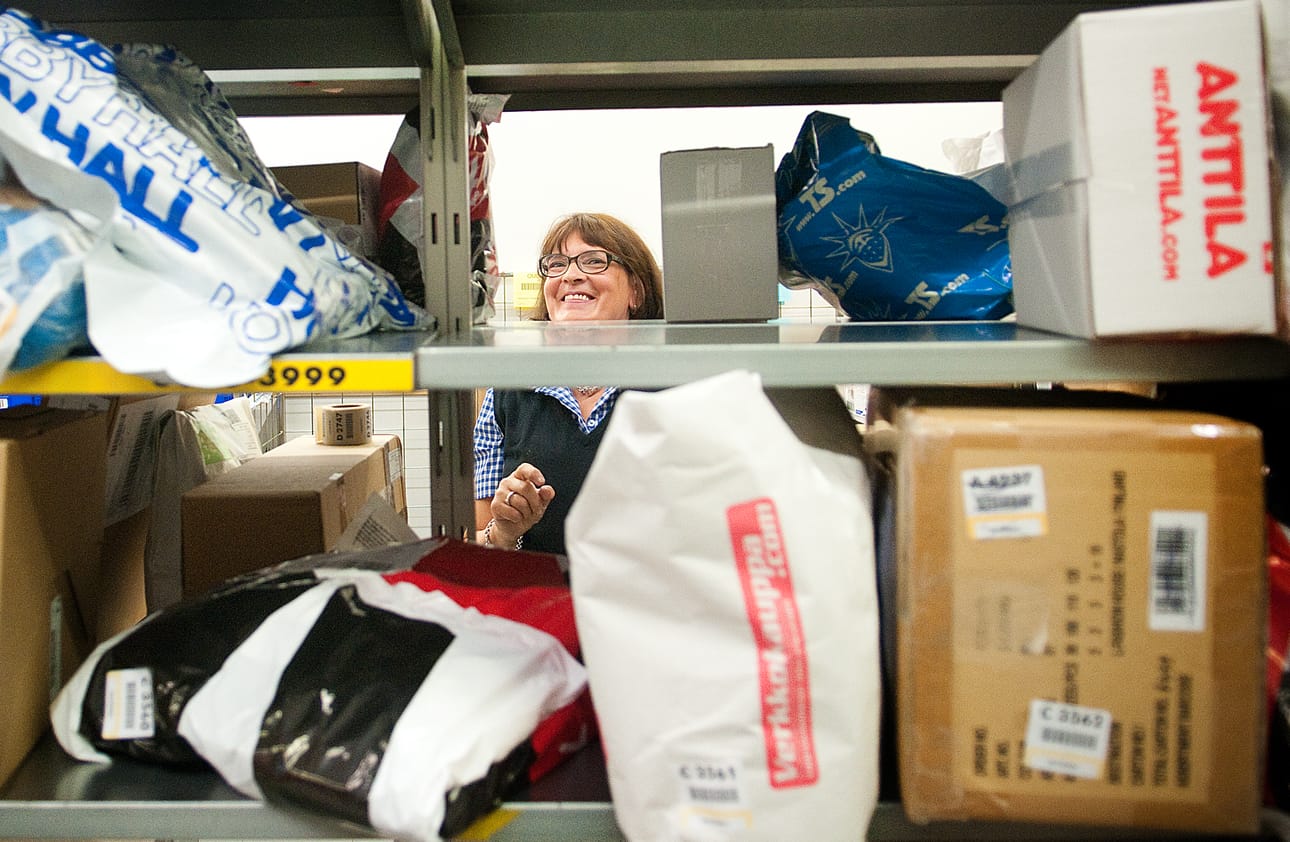 Kuusamon Ouluntaipaleen Postin myyntiesimies Eija Hentilä perkaa pakettisumaa. Pakettien kanssa pelaaminen syö ison osan työpäivästä.