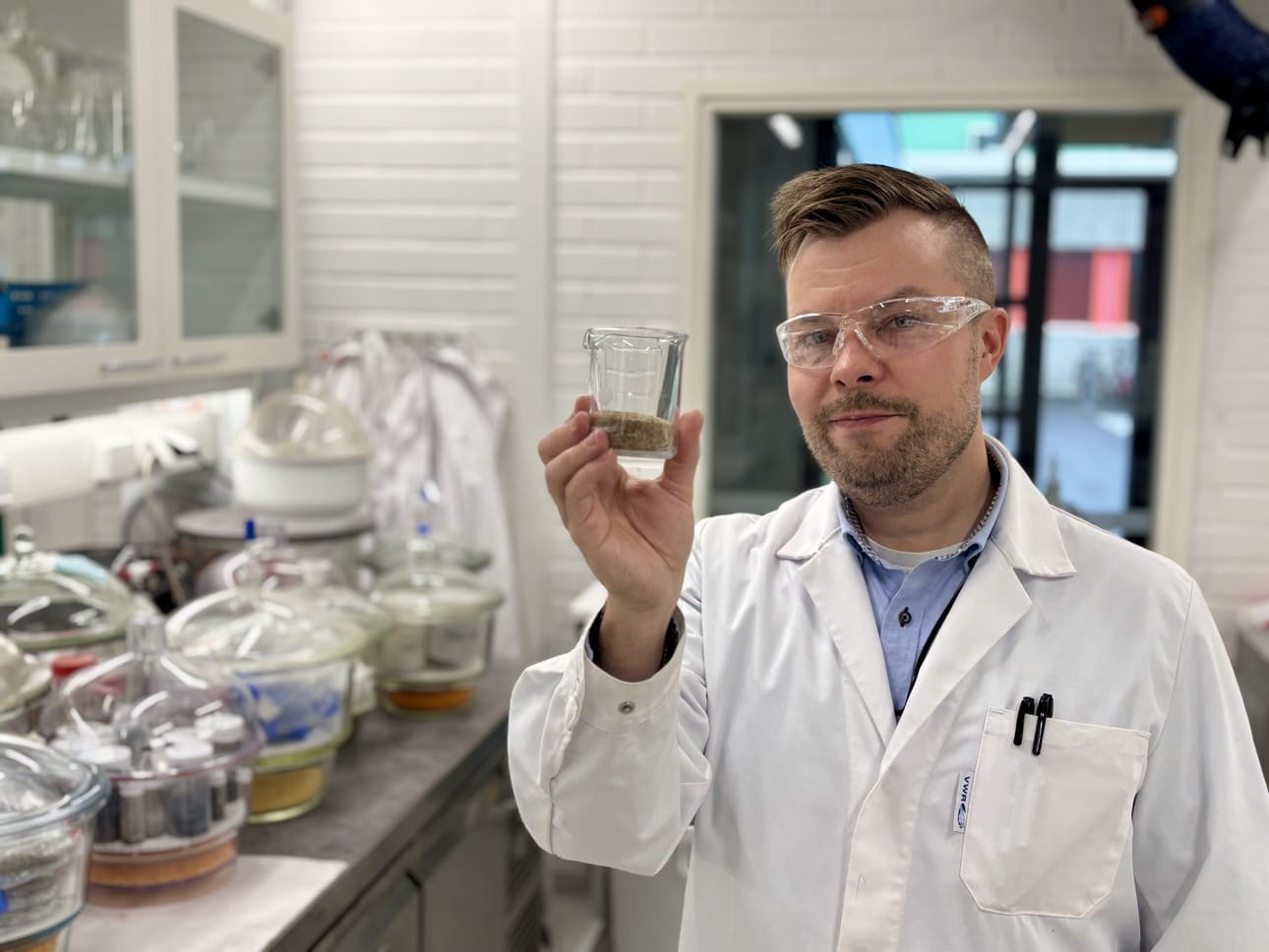 Apulaisprofessori Tero Luukkonen esittelee kemiallisesti muokattua hiekkaa, jolla pystytään poistamaan jätevesistä mikromuovit lähes kokonaan.