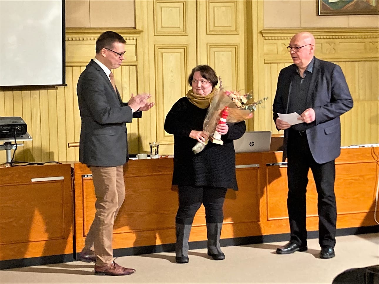 Helena Suominen sai majakkapalkinnon Kaskisten kaupunginvaltuustossa tiistai-iltana. Kaupunginjohtaja Markku Lumio (vas.) ja valtuuston puheenjohtaja Kari Häggblom onnittelevat.