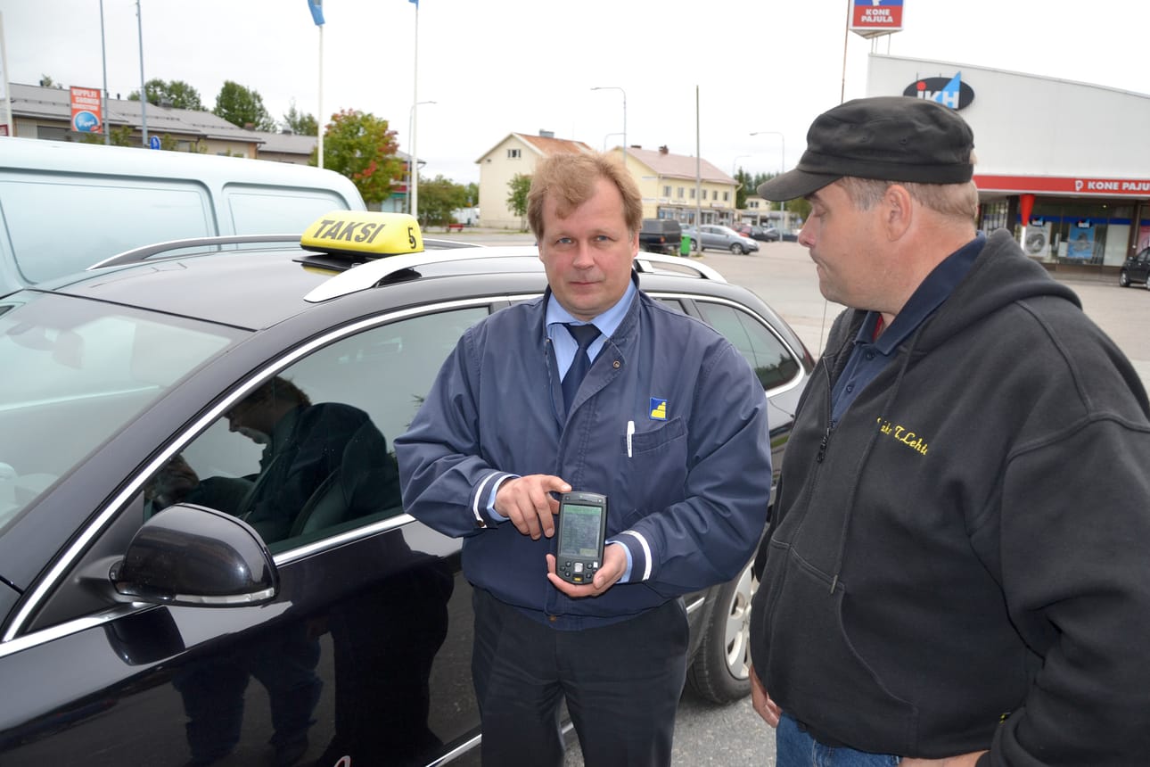 Taksiautoilija Mika Jaakkola esitteli kuun alussa ajoneuvopäätettä, johon yhteydenotto kelakyydistä tulee. Vieressä Teppo Lehto.