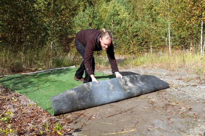 Kauhavan frisbeegolf ry:n puheenjohtaja Kalle Vainionpää rullasi uuden radan ensimmäisen väylän tiimattoa auki muutama viikko sitten. KUVA: ANU NAHKALA