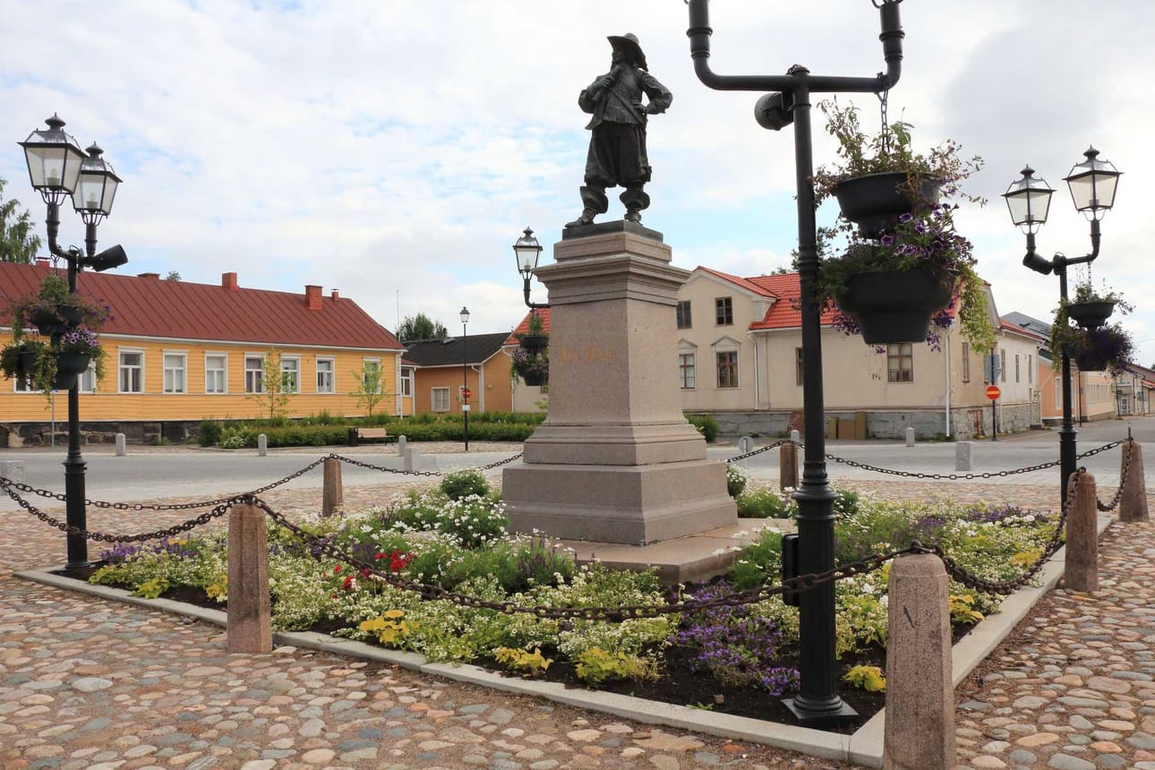Raahen Pekka saa ihailla kesän kukkaloistoa tänä vuonna ensimmäistä kertaa omista amppeleista. Juhlavuoden kunniaksi kukkien värit ovat sinivalkoiset.