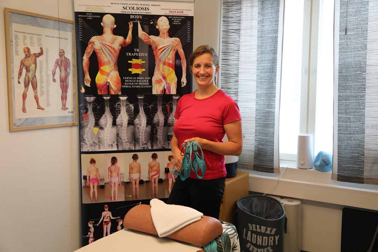 Jana Kocisovalla on kädessään vastuskuminauhat. Niitä käytetään spiraalistabilaation menetelmässä, jolla hoidetaan selän liikkuvuuden ja epätasapainon ongelmia.