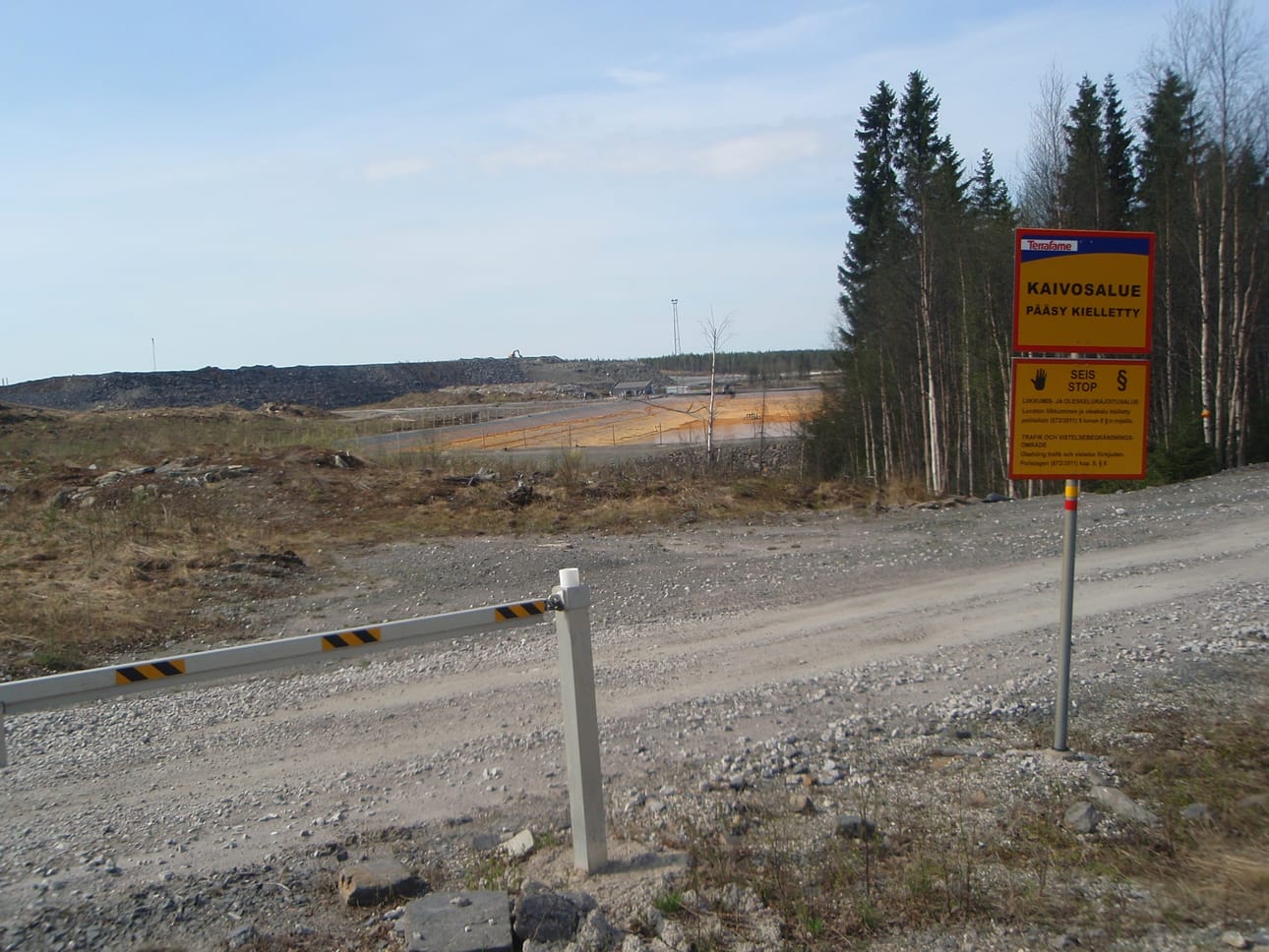 Talvivaaran kiistellyn kaivoksen jätevesien saostusallas päilyy kevätauringon paisteessa. Kyltti kertoo luvattoman oleskelun olevan kiellettyä kaivosalueella.
