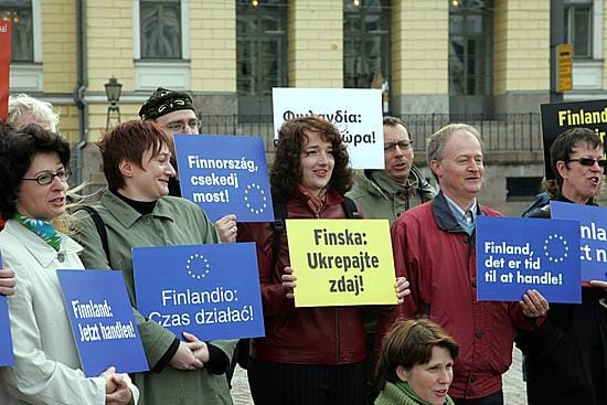 Amnesty Internationalin edustajat eri EU-maista kannattelivat "Toimi, Suomi" -kylttejä 17 eri kielellä Helsingin Senaatintorilla 19. toukokuuta 2006, kun Amnesty järjesti mielenilmauksen vaatien Suomelta jämäkkää ja tehokasta ihmisoikeuspolitiikkaa EU-puheenjohtajuuskaudella.