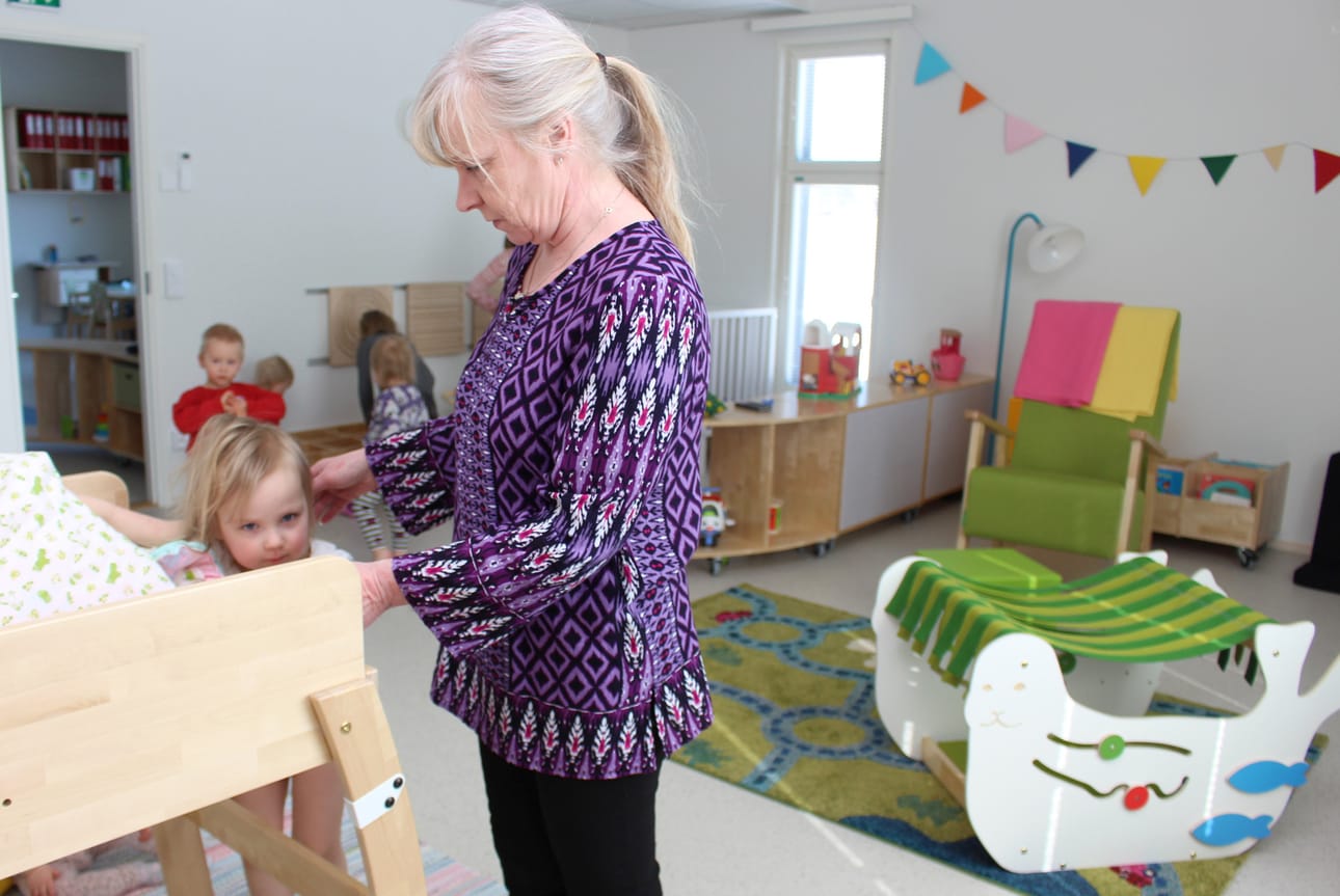 Pienimpien hoitolasten tiloissa Minttu heräillee viimeisenä päiväunilta. Kaverit ovat jo leikkimässä. Lastenhoitaja Heli Halmetoja varmistaa, että lapsi pääsee turvallisesti kaappisängystä alas.