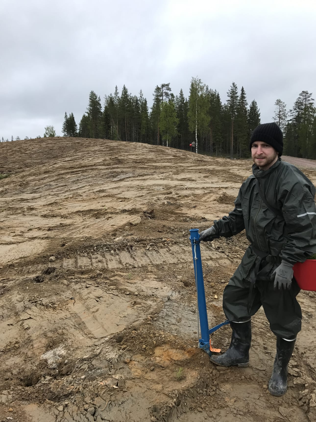 Tyson Kestel istuttamassa puita maanmuokkauksen jälkeen.