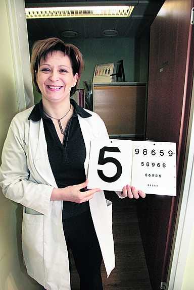 Optikko Anna Maija Kantola esittelee näön tarkastuksessa käytettäviä välineitä.