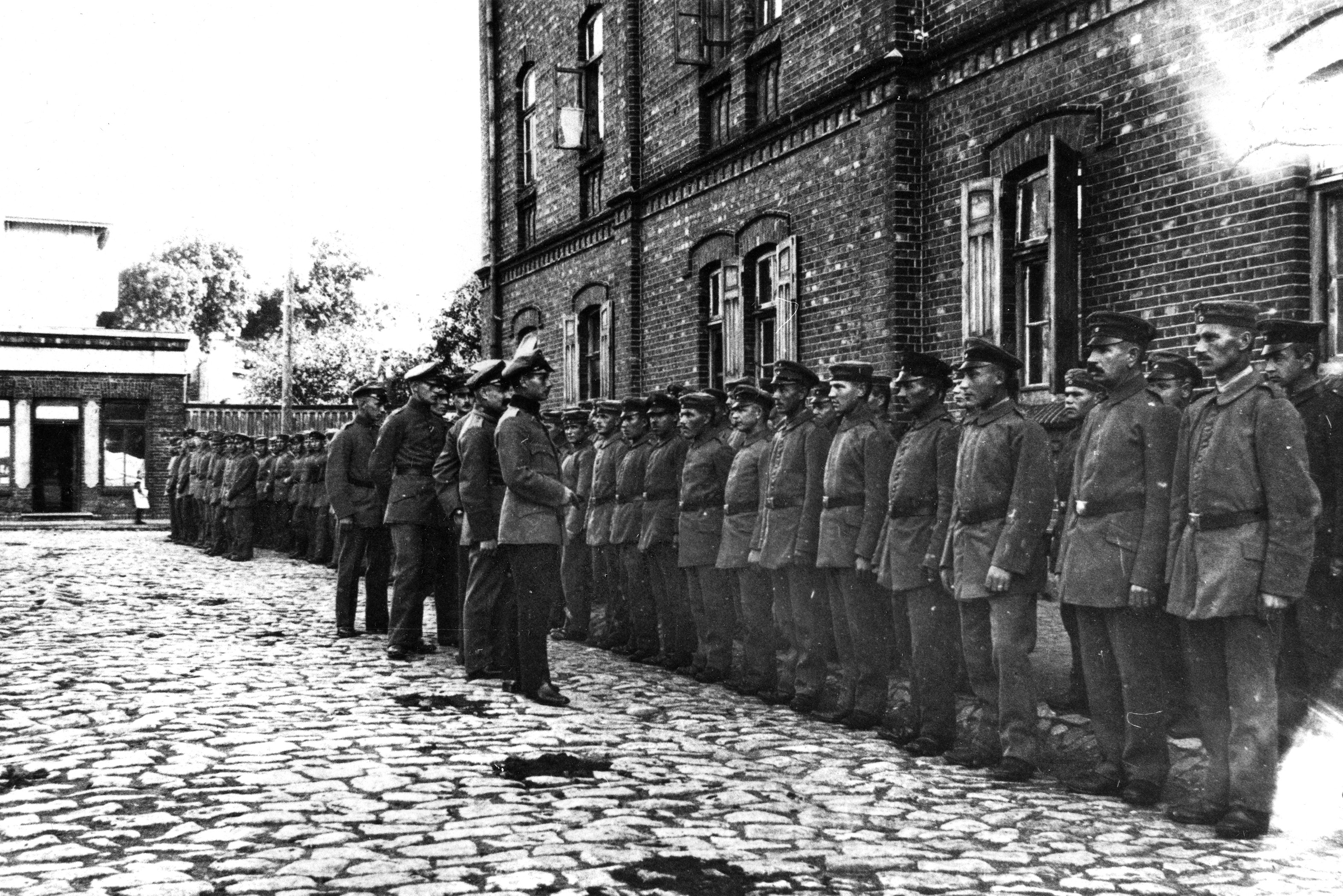 Suomalaisia jääkäreitä kasarmirakennuksen edessä Liepajassa ensimmäisen maailmansodan aikoihin. Vuosina 1915–18 jääkärikoulutuksen kävi läpi Saksassa lähes 2000 vapaaehtoista. Kuninkaallisen Preussin Jääkäripataljoona 27:n koulutus huipentui Liepajassa.