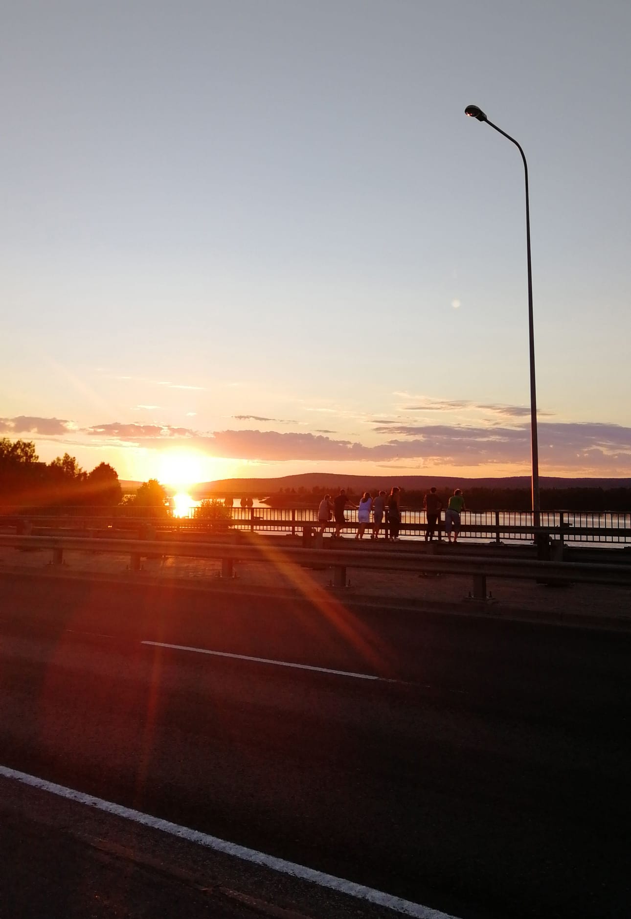 Yötön yö. Jessica Kokon kuvassa turistit ihailevat keskiyön aurinkoa Jätkänkynttiläsillalta. "Mitä esittelisin kotikaupungistani vieraille? Kesällä ehdottomasti yöttömän yön ja talvella tietenkin Napapiirin ja joulupukin", Kokko kertoo.