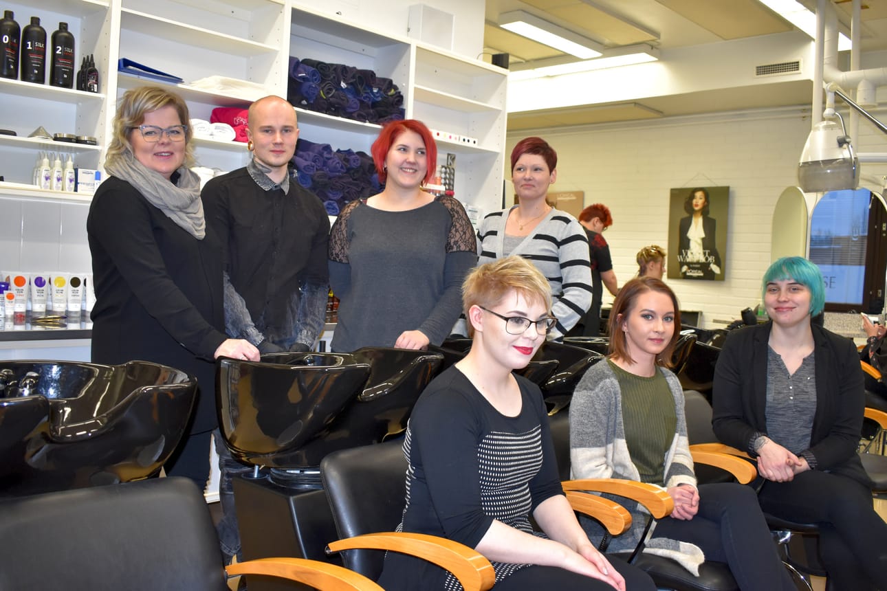 Parturi-kampaajaopettaja Jaana Mustonen (ylh.vas.) sekä parturi-kampaajat Marko Välijärvi, Satu Pesonen, Sanna Vähäkuopus, Marianne Kilpivaara, Noora Määttä ja Mirka Sarajärvi ovat valmiina ensi viikon hyväntekeväisyyspäivää varten.