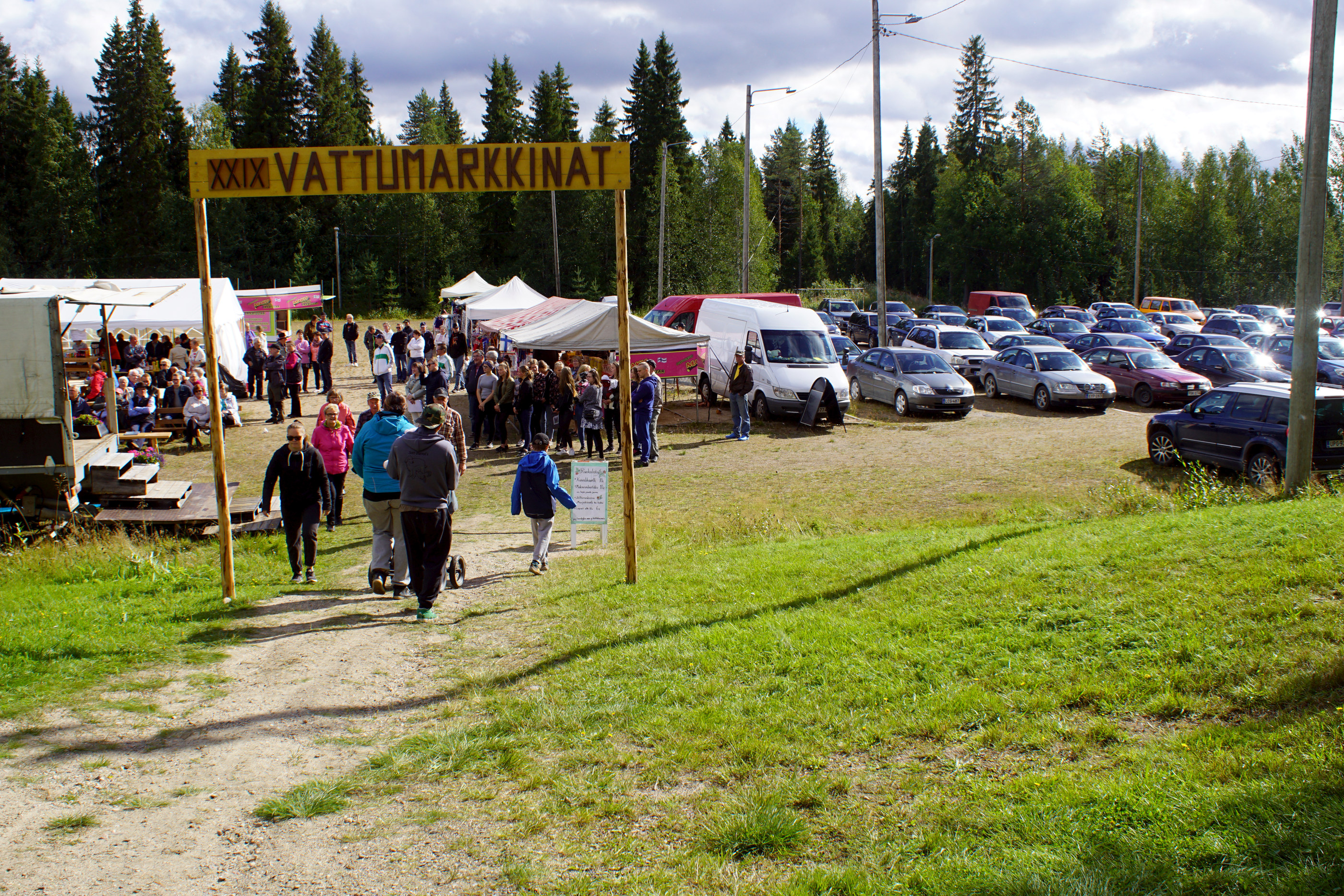 Vettä kertyi markkina-alueelle, mutta poiskin se lähti. Iivari Jurmu varmistelee, että esiintymislava pysyy kuivana. Esko ja Hilkka Piipponen sekä Kauko Kuukasjärvi varmistivat.