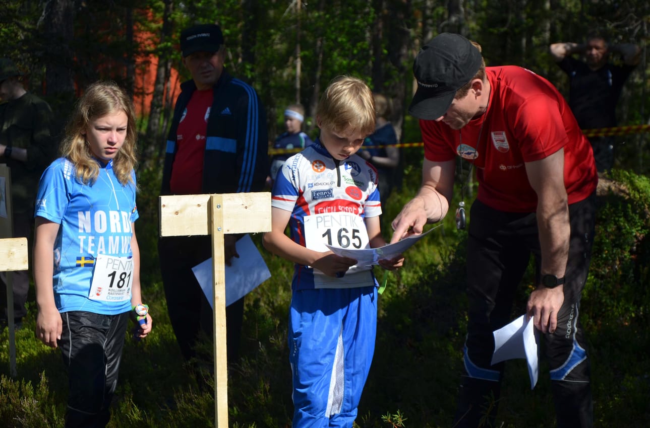 Mauri Hiltunen opastaa Erkka Petreliusta lähtöpaikalla. Vuoroaan odottaa Vetja Triipponen.