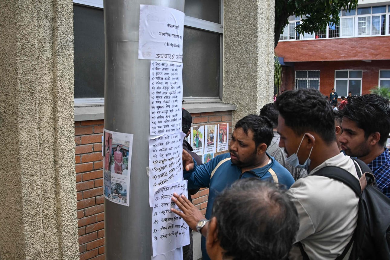 Omaiset lukemassa kadonneiden henkilöiden listaa perjantaina Kathmandussa.