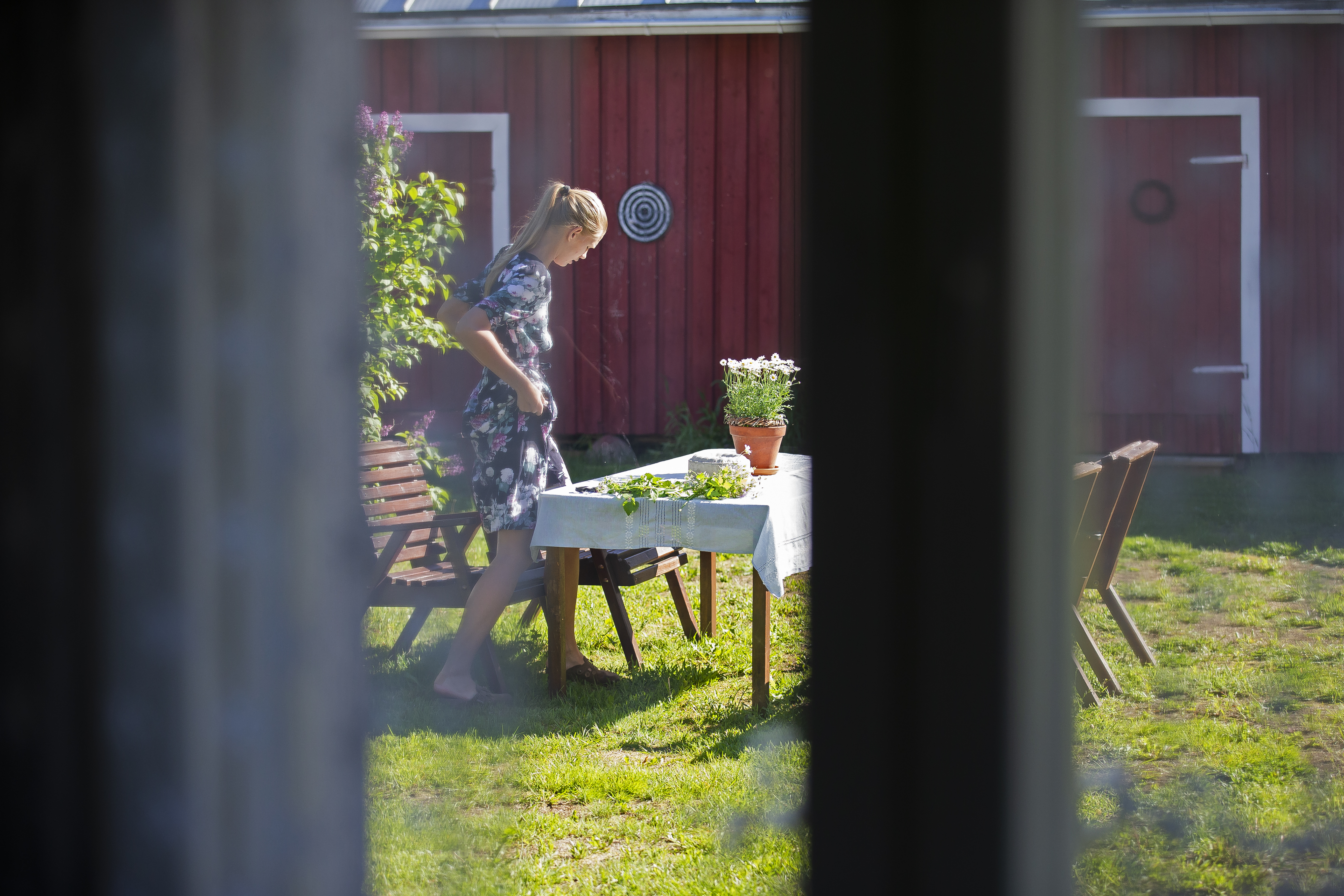 Pihalla Adalmiina valmistautuu kukkaseppeleiden tekoon.