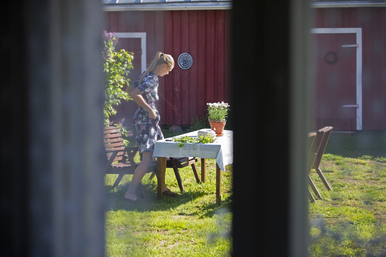 Pihalla Adalmiina valmistautuu kukkaseppeleiden tekoon.