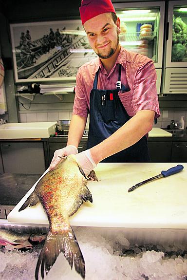 Kalamyyjä Jussi Haanpää näyttää, kuinka lahnasta poistetaan sisälmykset. Munuaiset ovat kiinni selkärangassa, joten<br>ne täytyy irrottaa erikseen.
