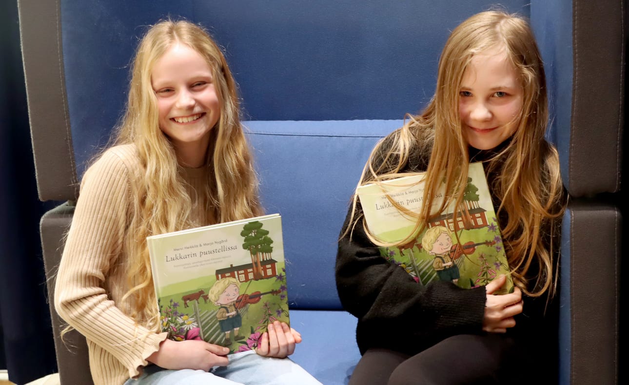 Kuortanelaiset koulukaverukset Nora Nurmik ja Alina Rantanen lukivat Alvarin koululle lahjoitetut Lukkarin puustellissa -kirjat koulunsa ensimmäisten joukossa.