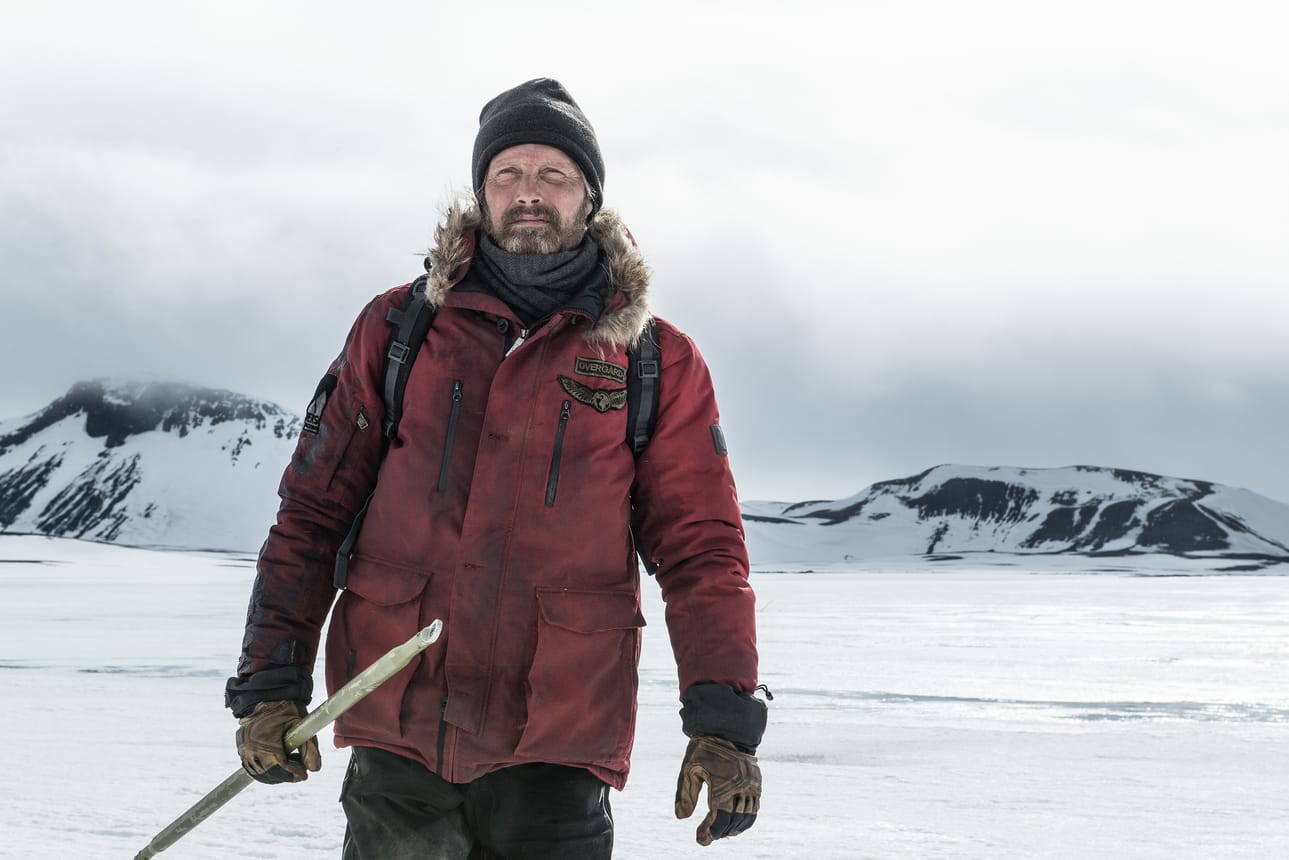 Mies yrittää lento-onnettomuuden jälkeen pysytellä hengissä jäisillä arktisilla lakeuksilla kylmyyden ja jääkarhun uhkaamana. Pääosassa on tanskalainen Mads Mikkelsen.
