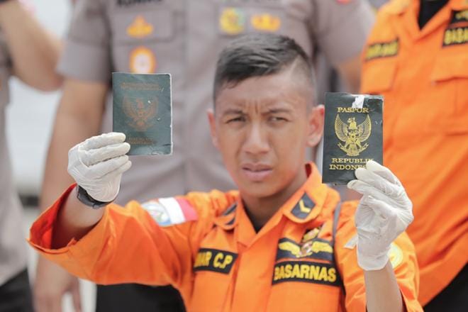 Indonesialainen pelastustyöntekijä näyttää passeja, jotka kuuluvat Indonesian maanantaisessa lentoturmassa menehtyneille. Koneen kyydissä oli 189 ihmistä, ja eloonjääneitä ei ole. KUVA: MAST IRHAM/EPA