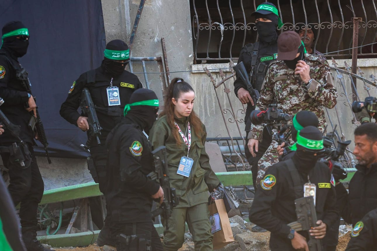 Hamasin taistelijat saattoivat israelilaista naispanttivankia, joka luovutettiin Punaisen Ristin edustajille Jabaliassa torstaina. LEHTIKUVA/AFP