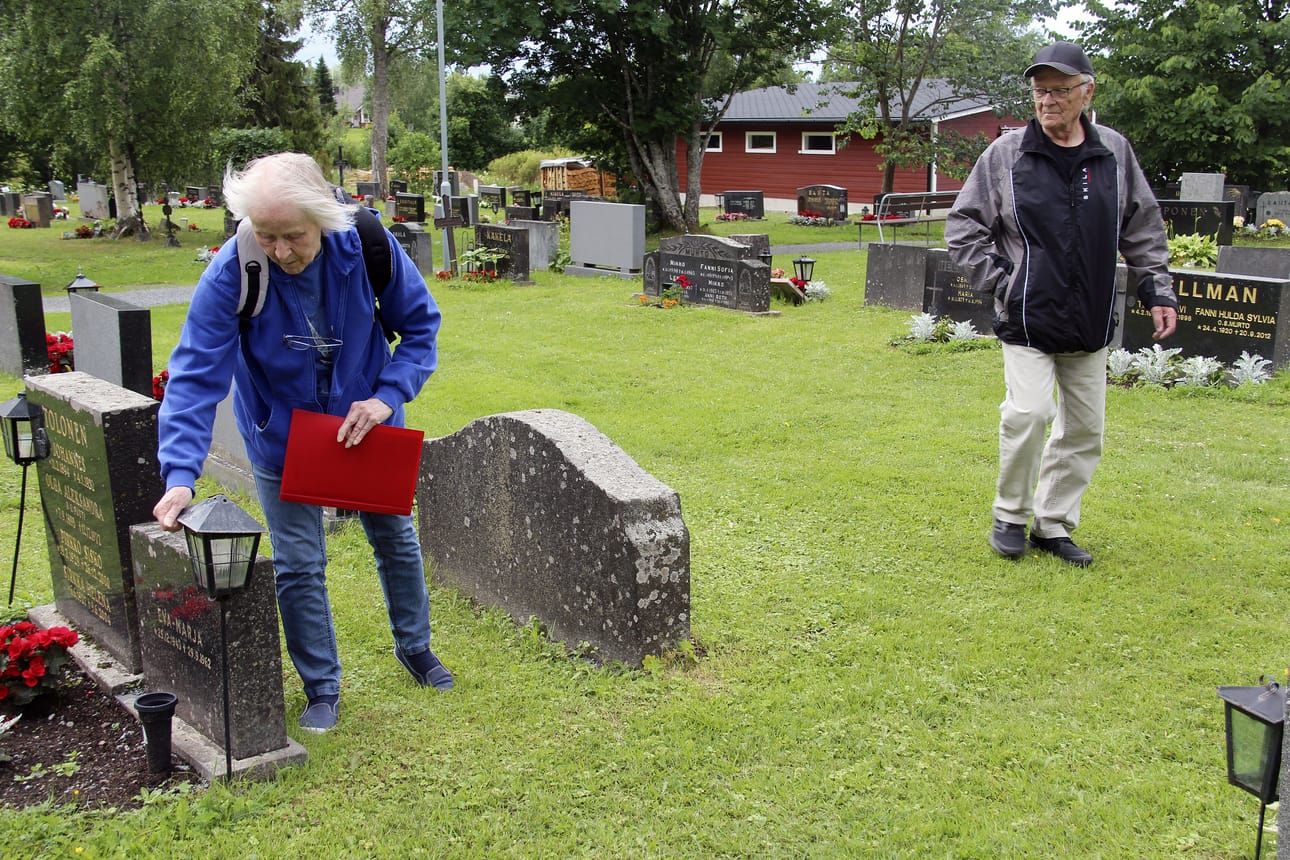 Oulaisten hautausmaalla aletaan ensi kesänä kokeilla yksivuotisten kesäkukkien sijaan monivuotisia perennaistutuksia. Vaihtoehtoa tarjotaan omaisille, joiden läheisten haudoista huolehtii seurakunta. Monivuotisiin kukkiin siirtymistä suositellaan muillekin. Kuvan henkilöt eivät liity uutiseen, vaan ovat tehneet hautapaikoista nimiluettelot hautapaikkojen löytämiseksi vuonna 2024.