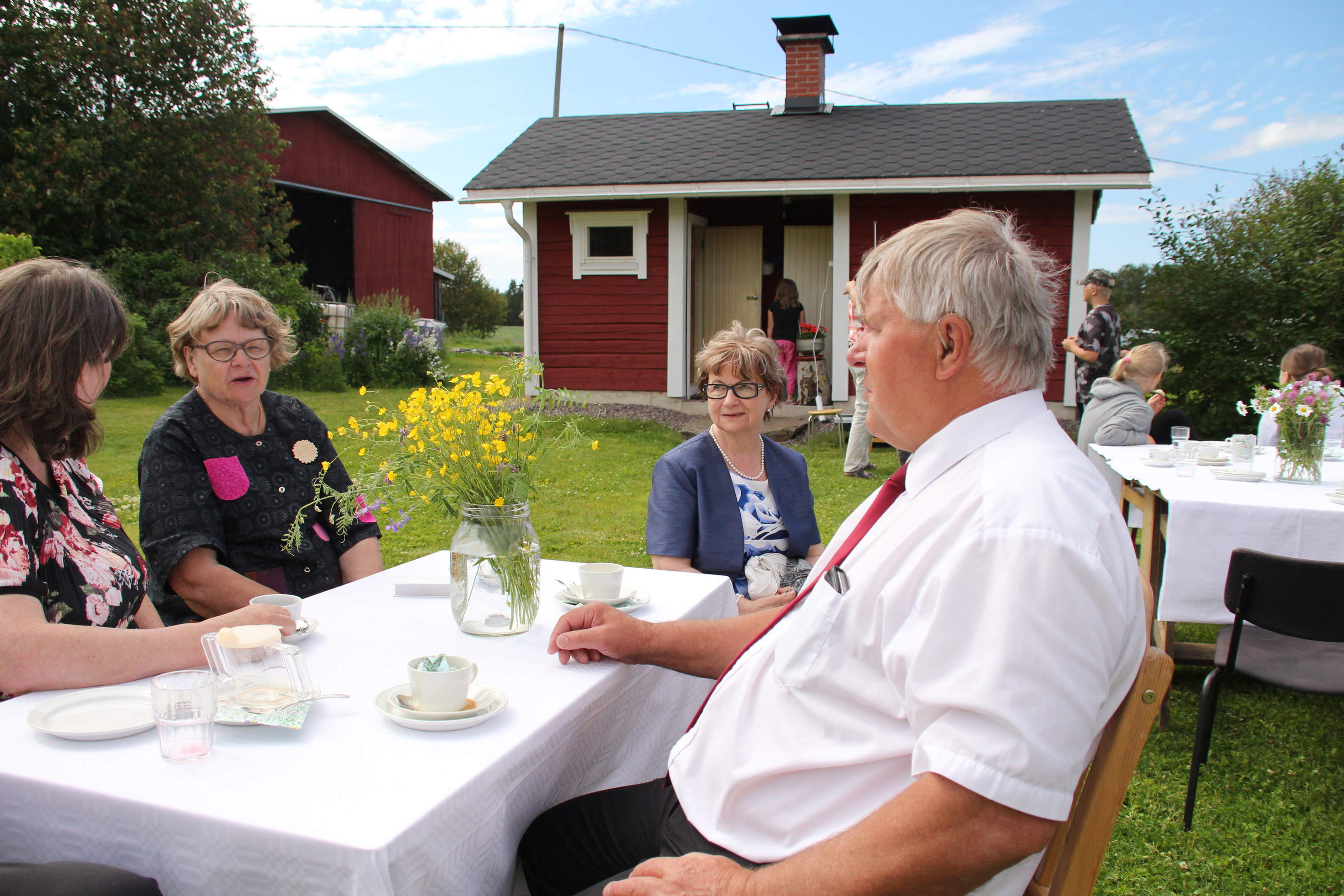 Juhla oli Ylipatokosken viihtyisässä pihapiirissä. Kantolan pariskunnan kanssa kahvilla Sinikka Kauppinen (pöydän päässä).