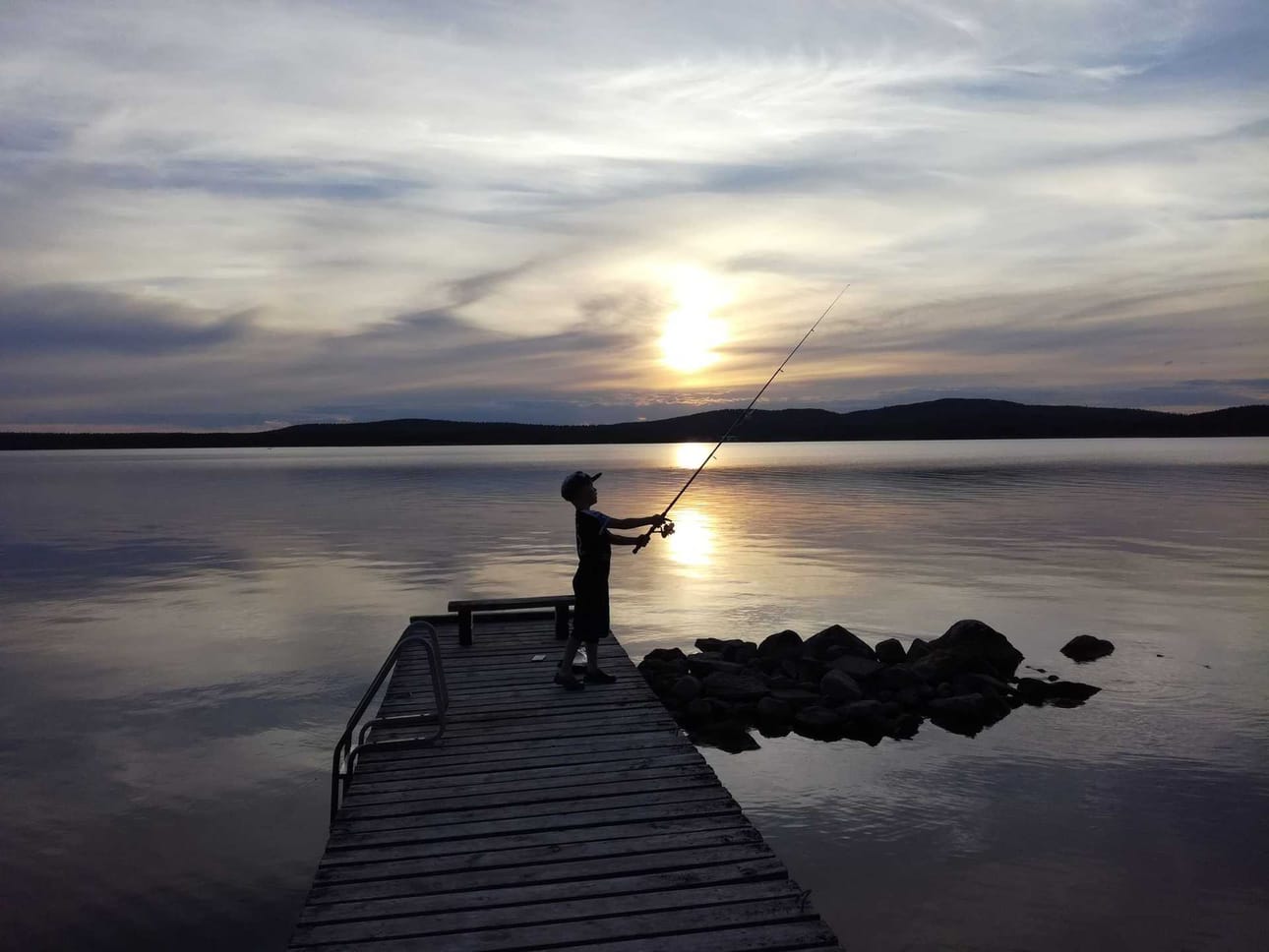 Kesäyö, poika ja onki. Kuva otettu Inarissa 2. heinäkuuta.