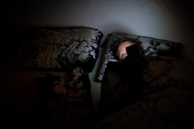 Kännykän selaileminen illalla aiheuttaa kaksi ongelmaa nukahtamiseen. Sisältö voi virkistää ja näytön valo siirtää vuorokausirytmiä. Kuva: Tomi Kosonen