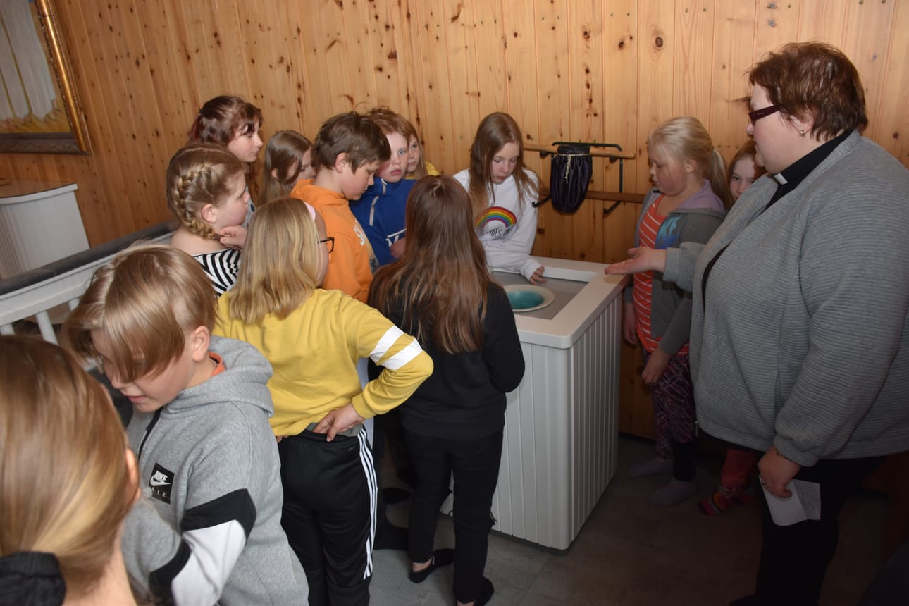 Koululaiset tutustumassa Posion kirkkoon viime keväänä. Esittelijänä toimi kirkkoherra Leena Pudas.