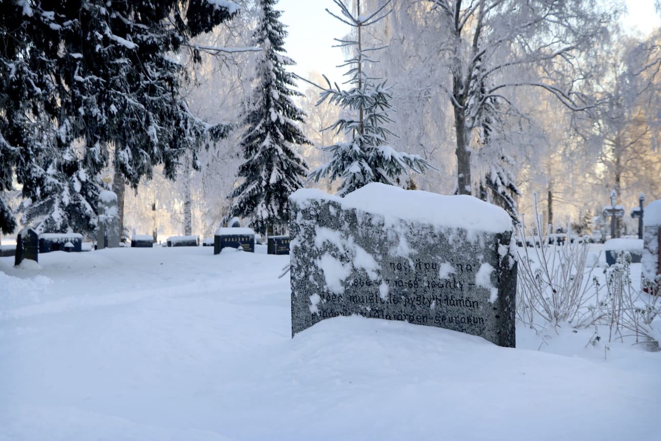Nälkävuosina kuolleiden muistokivi erottuu lumenkin alta. Kivi sijaitsee kirkon sivustalla, suunnilleen oikeanpuoleisten sivuovien kohdalla.