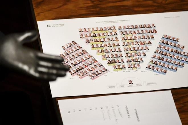 Eduskunnan virkamies pitää käsissään hanskoja tartuntavaaran vuoksi eduskunnassa, jossa pidetään Uudenmaan sulkemista koskeva täysistunto illalla. KUVA: LEHTIKUVA / VESA MOILANEN