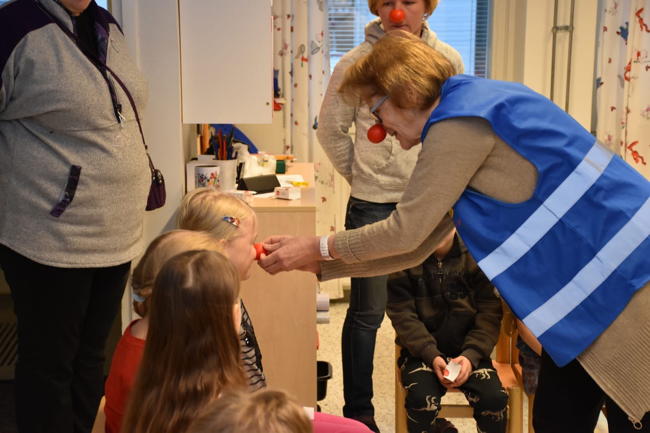 Vuokko Jokela kertoi Nenäpäivän merkityksestä ja auttoi lapsia asettamaan punaisen nenän paikoilleen.