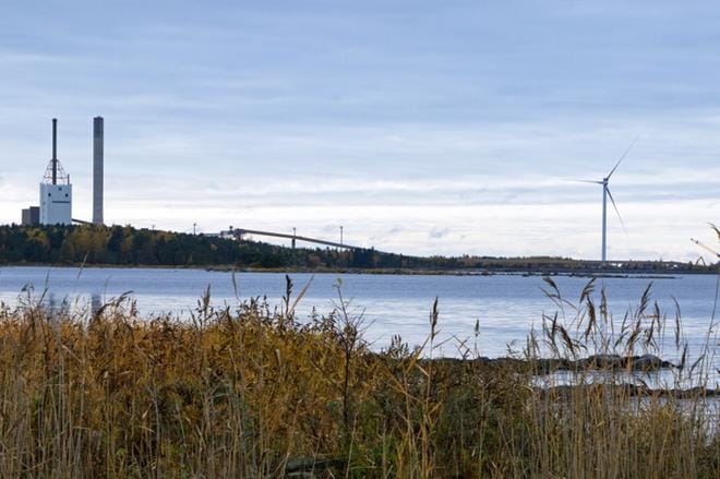 Kuvassa oikealla oleva uusi tuulivoimala on Pohjolan Voiman alueella Karhusaaressa. Hiilivoimalaitos on poistettu käytöstä. KUVA: AUNE WARONEN