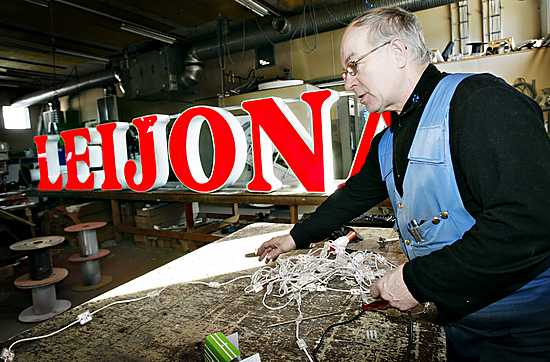Leijona-valomainos saa entisen loistonsa Oulun Neonin hallissa. Peltiseppä Jouko Jussila vaihtaa mainoksen neonputket ledvaloihin.