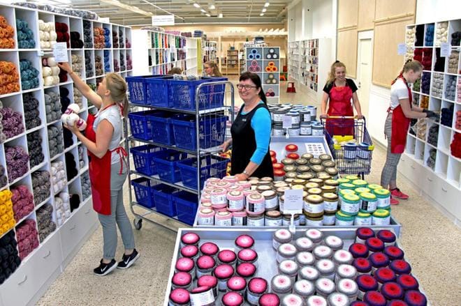 – Uusi myymälämme on 1 200 neliötä ja koko kiinteistö 1 950 neliötä. Kullakin käytävällä on oma teemansa, joten tuotteet löytyvät helposti, esittelee Lankava oy:n toimitusjohtaja Kirsti Karppinen (kesk.). Hyllyjä täyttävät kesätyöntekijät Katariina Makkonen, Veera Prusti ja Neea Rintala. KUVA: MIA KÄRKKÄINEN