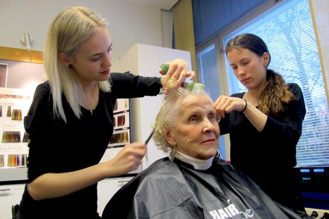 Lucia-mummoehdokkaiden hemmottelupäivä oli Bertta Vihannolle aivan uusi kokemus. Ensimmäisen vuoden parturi-kampaajaopiskelijat Roosa Tervasmäki ja Sini Tervasmäki nauttivat mummojen seurasta ja ilosta. Kuvat: Katja Lahti