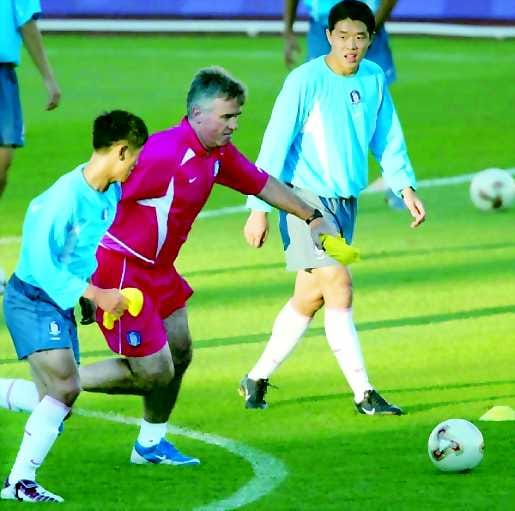 Valmentaja vedossa. Etelä-Korean valmentaja Guus Hiddink piiskaa pelaajistoaan yhä parempiin suorituksiin. Lee Young-pyo (vas.) ja Hyun Young-min ottavat homman tosissaan.