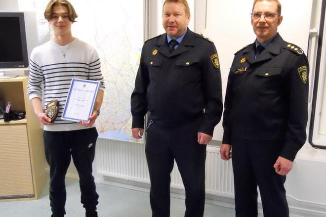 Karijoen ylikyläläinen Aarni Savolainen vastaanotti pelastuslaitoksen kunniakirjan ja -kilven numero 96 möykkyläiseltä palomestarilta Petri Järvensivulta ja kurikkalaiselta palopäällikkö Juha Turkulaiselta. KUVA: KARI AURESSALMI