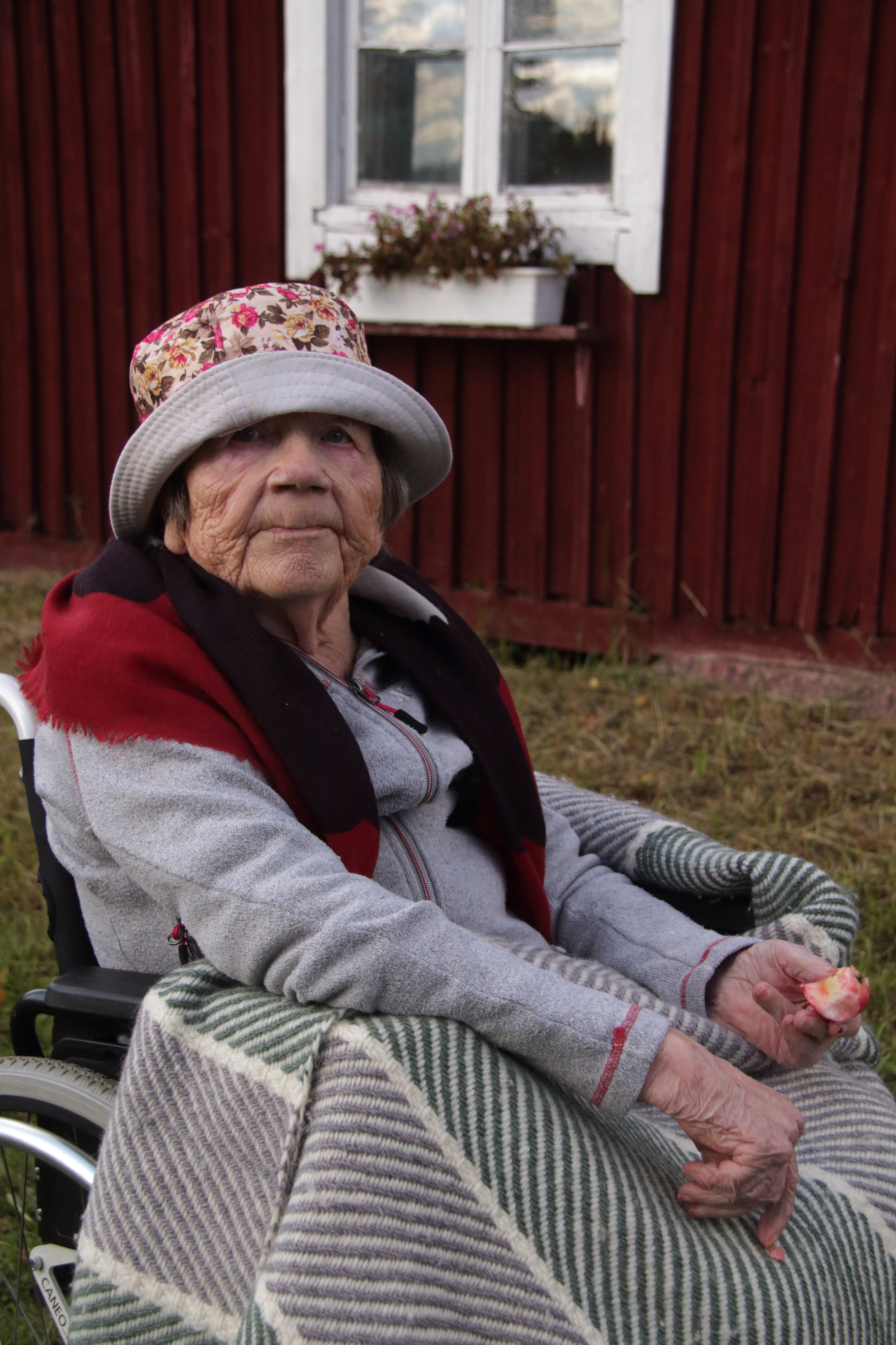 Sirkka Koskela istui seinän vieustalla ja maisteli kypsää omenaa.