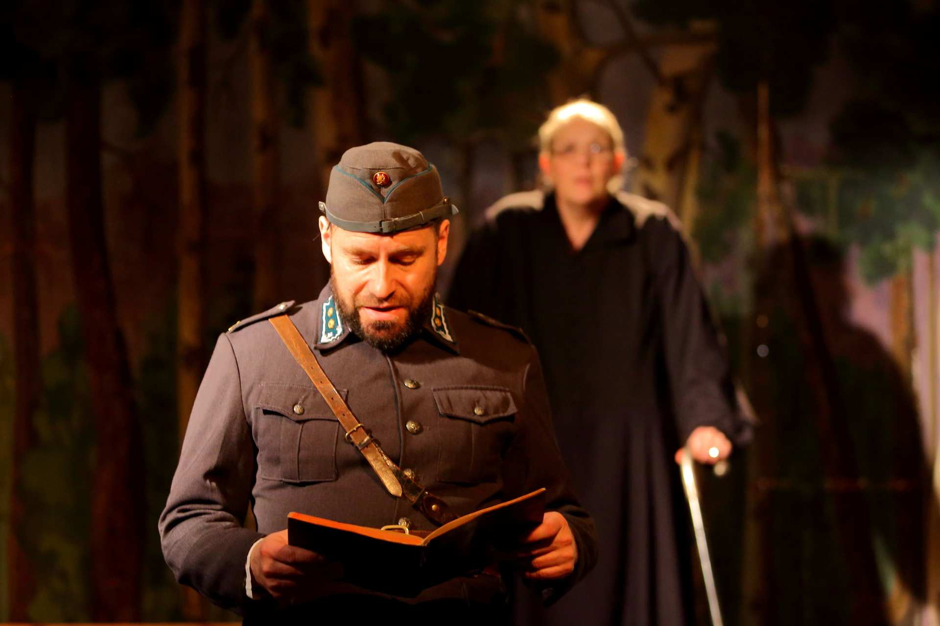 Sotilas (Leo Hänninen) lukee sotapäiväkirjasta Aaro Aronahon kaatumispäivän merkintöjä. Taustalla Impi Aronaho (Päivi Tuomainen).