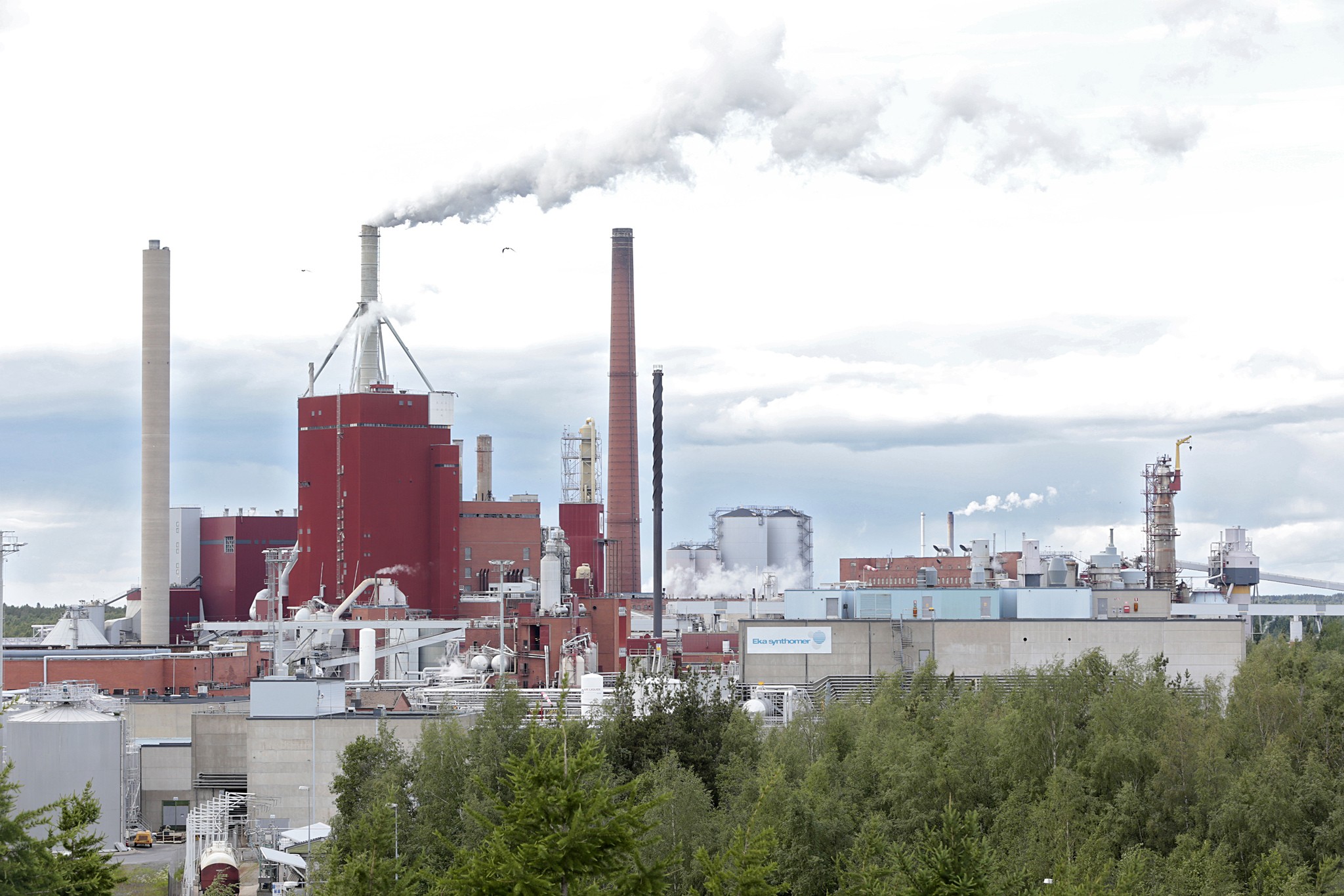 Kuvassa keskellä oleva tiilipiippu on ainoa purettavista rakennuksista, joka näkyy tehdasalueen ulkopuolelle.