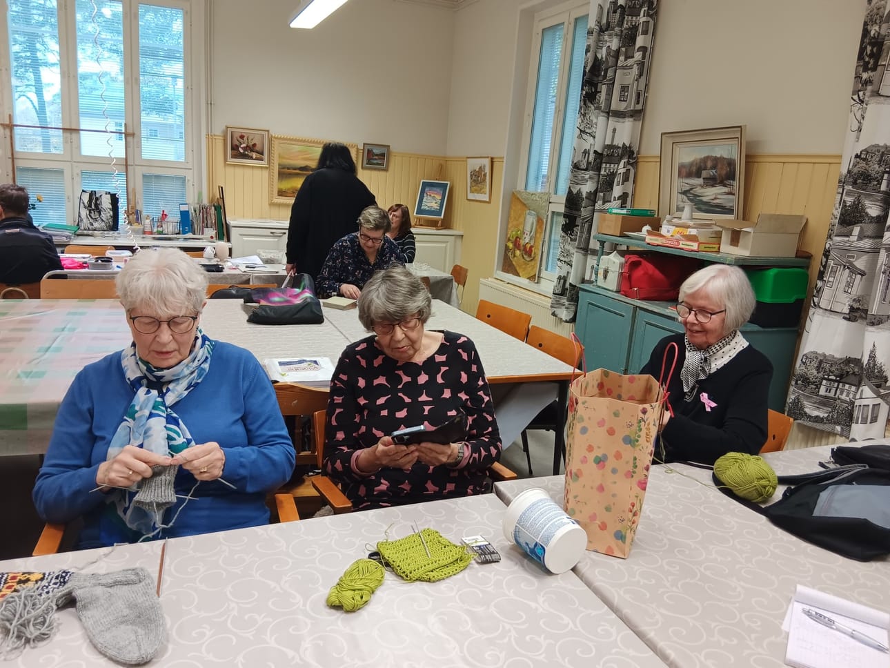 Maila Eriksson, Tuula Stenroos ja käsityöryhmän ohjaaja Sirkka-Liisa Suvanto-Airistola tuumaavat, että kudonnan ja virkkauksen äärellä on helppo rupatella.