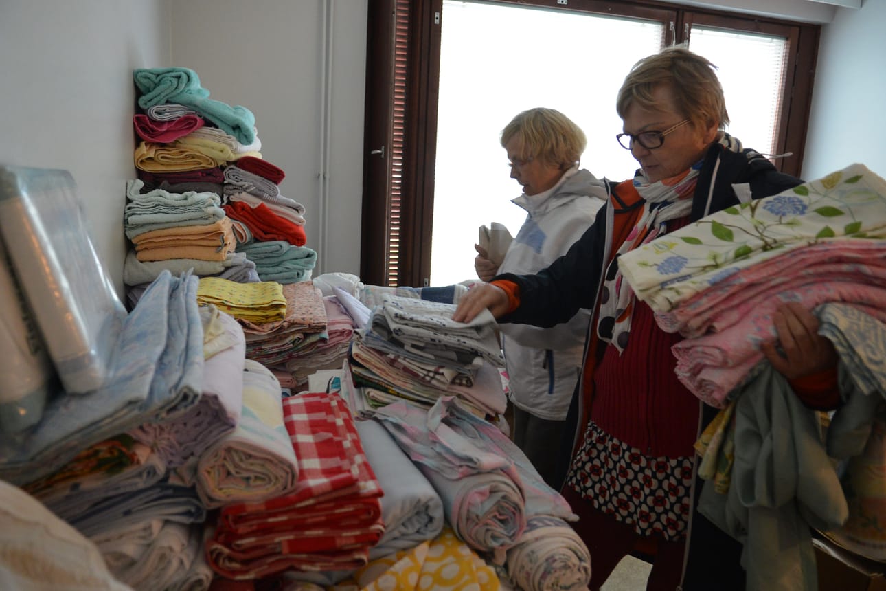 Perjantain talkoissa ystäväperheet jakoivat lahjoitustavaroita jokaiselle perheelle tarpeellisen määrän. Raija Haapakoski ja Anitta Tauriainen valitsivat pakolaisystävilleen liinavaatteita.